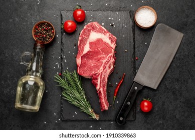 
Raw Cowboy Steak With Spices On Stone Background