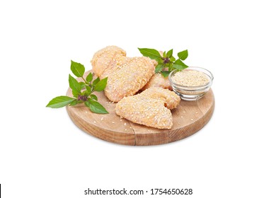 Raw Crispy Chicken Boneless Drumstick Breaded In Bread Crumbs And Sesame On A Wooden Board With Oregano. Ready To Fry. Breaded Crunchy Fresh Meat Made Of Chicken Wings. Isolated On White Background 