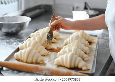 Raw croissants on a baking tray, prepared for baking. - Powered by Shutterstock