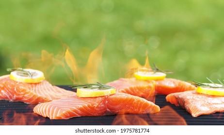 Raw delicious grilled salmon steaks placed on barbecue grill, close up. Fresh meat on fire.