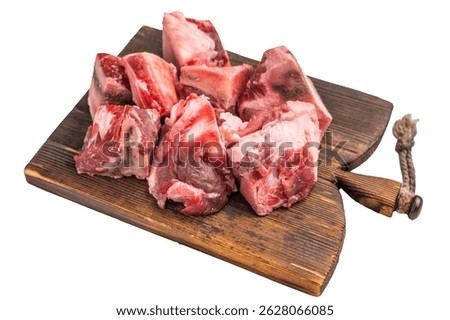 Raw diced Beef meat with bones for stew or goulash on wooden board isolated on white background. top view.