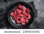 Raw Diced game meat of wild venison dear. Black background. Top view.