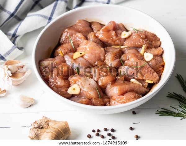 Raw diet marinated turkey meat with garlic,\
ginger and teriyaki sauce in a white bowl. Marinating meat for\
cooking barbecue\
