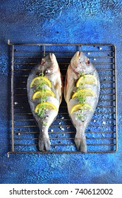 Raw Dorado Fish With Spices And Lime, On A Grill, Top View Dark Blue Background Copy Space