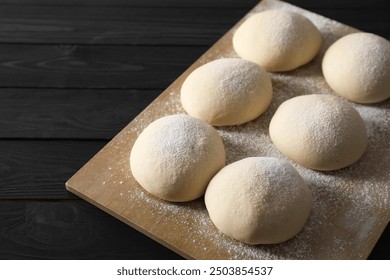 Raw dough balls on black wooden table - Powered by Shutterstock