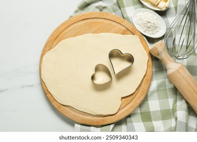 Raw dough, cookie cutters, flour, whisk and rolling pin on white marble table, top view - Powered by Shutterstock