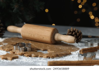 Raw dough, cookie cutters, pine cone and rolling pin on grey table, closeup - Powered by Shutterstock