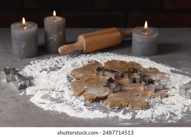 Raw dough, cookie cutters, rolling pin and burning candles on grey table - Powered by Shutterstock