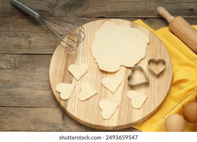Raw dough, cookie cutters, rolling pin and eggs on wooden table, above view - Powered by Shutterstock