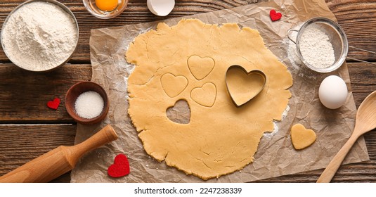Raw dough and ingredients for preparing tasty heart shaped cookies on wooden background. Valentines Day celebration - Powered by Shutterstock