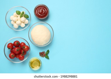 Raw Dough And Other Pizza Ingredients On Light Blue Background, Flat Lay. Space For Text