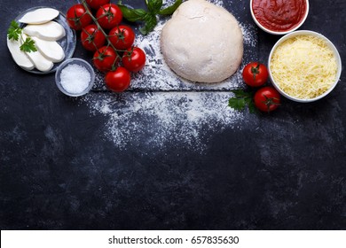 Raw Dough For Pizza With Ingredients And Spices On Black Background.overhead With Copy Space