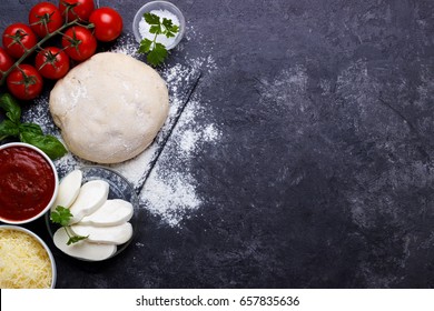 Raw Dough For Pizza With Ingredients And Spices On Black Background.overhead With Copy Space