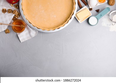 Raw dough and traditional English apple pie ingredients on light grey table, flat lay. Space for text