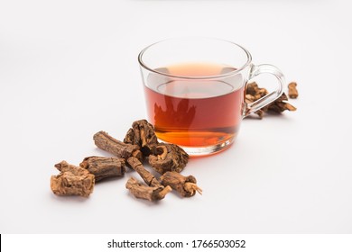 Raw Dried Indian Ayurvedic Sarsaparilla with Kadha Or Tea In A Transperant Glass Or Cup, Selective Focus