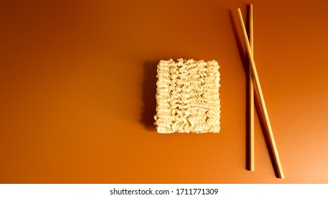 Raw dried instant noodles with chopsticks with copy space. Asian food. minimalism. pasta, for the preparation of which it is enough to pour boiling water and wait a few minutes. Vermicelli, spaghetti - Shutterstock ID 1711771309