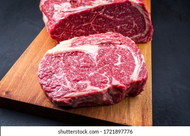 Raw dry aged wagyu entrecote beef steak roast as top view on a modern design wooden board 