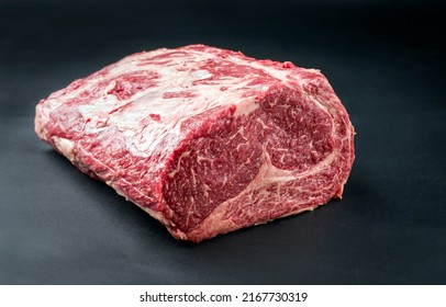 Raw dry aged wagyu entrecote beef steak roast as closeup on a black background with copy space 