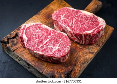 Raw dry aged wagyu entrecote beef steak roast as closeup on a rustic wooden cutting board  - Powered by Shutterstock