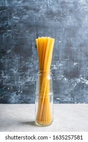 Raw dry spaghetti on the rustic wooden background. Selective focus.
