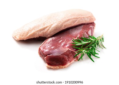 Raw duck breast pieces garnished with parsley and rosemary isolated on white background
