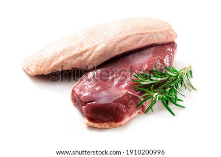 Raw duck breast pieces garnished with parsley and rosemary isolated on white background
