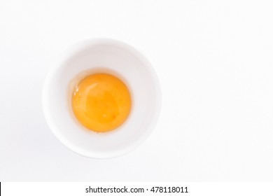 Raw Egg Yolk In A Bowl On A White Background.