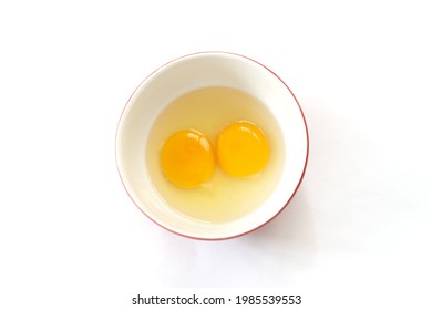 Raw eggs, top view of two raw eggs yolk in bowl on isolated white background.