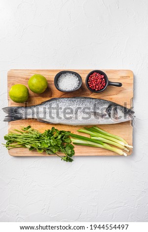 fresh whole sea bass fish on a black board