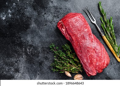 Raw fillet Tenderloin beef meat for steaks with thyme and rosemary. Black background. Top view. Copy space. - Shutterstock ID 1896648643