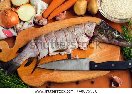 Raw fish. Cutting fresh pike women's hands.