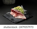 Raw fish with fresh cut served as sushi on a black background