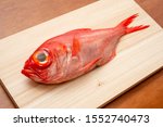 Raw fish on a cutting board. The name of this fish is "Splendid alfonsino".