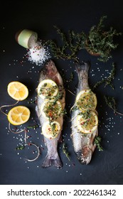 Raw Fish On A Dark Background. The Fish Is Cooked With Lemon And Thyme, Spices. Dinner With Stuffed Fish. Fresh Catch. Seafood Food Styling