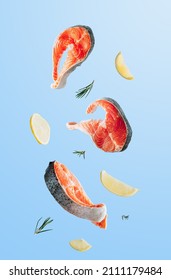 Raw fish salmon steak with lemon and rosemary on blue background. Food levitation concept - Shutterstock ID 2111179484