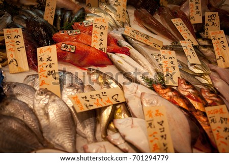 Raw fish sold on a famous Japanese fish market Tsukiji. Tokyo, Japan. The Japanese text means each fish name.
