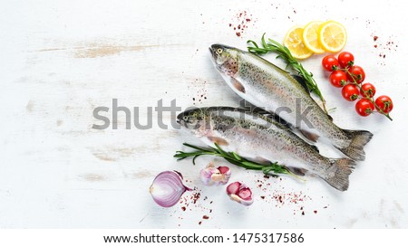 Raw fish with vegetables on a white wooden background. Fish trout. Top view. Free space for your text.