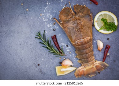 Raw flathead lobster shrimps with herbs and spices, fresh slipper lobster flathead for cooking on dark background in the seafood restaurant or seafood market, Rock Lobster Moreton Bay Bug