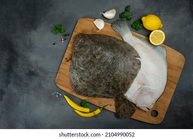 Raw flounder fish with spices. Seafood on a gray stone background. Top view. Free copy space. BIO fish.