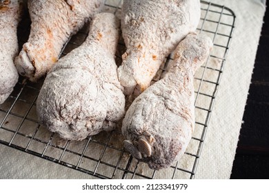 Raw Floured and Spiced Chicken Drumsticks on a Wire Rack: Floured uncooked chicken legs being prepped for frying - Shutterstock ID 2123341979