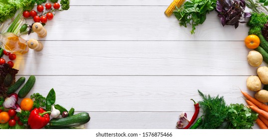 Raw food diet banner. Frame of fresh organic vegetables with spices and oil on white wooden background, panorama with empty space