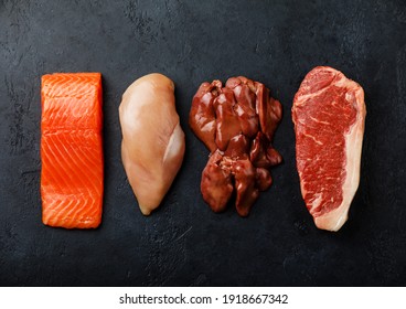 Raw food selection for Carnivore diet Salmon fish Steak, Chicken meat, Chicken liver, Beef meat Steak on dark background