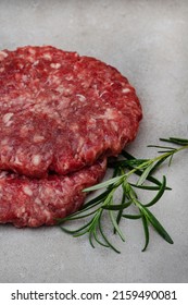 Raw Free Range 100% Beef Burger Patties On Mottled Grey With Copy Space