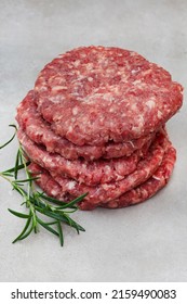 Raw Free Range 100% Beef Burger Patties On Mottled Grey With Copy Space