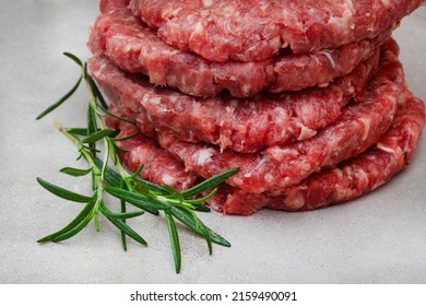 Raw Free Range 100% Beef Burger Patties On Mottled Grey With Copy Space