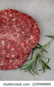 Raw Free Range 100% Beef Burger Patties On Mottled Grey With Copy Space