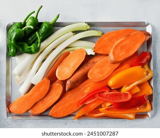 Raw, fresh assorted vegetables for grilling or baking: sweet potato, red and green bell peppers,Summer Onions. Top view. Healthy food.