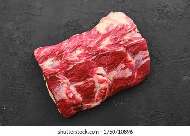 Raw fresh beef chuck center roast on black background