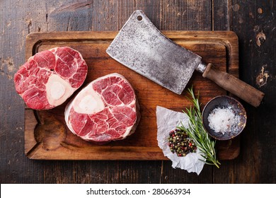 Raw fresh cross cut veal shank and seasonings for making Osso Buco on wooden cutting board with meat cleaver - Powered by Shutterstock