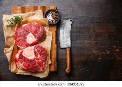 Raw fresh cross cut veal shank and seasonings for making Osso Buco on wooden cutting board with meat cleaver - Powered by Shutterstock